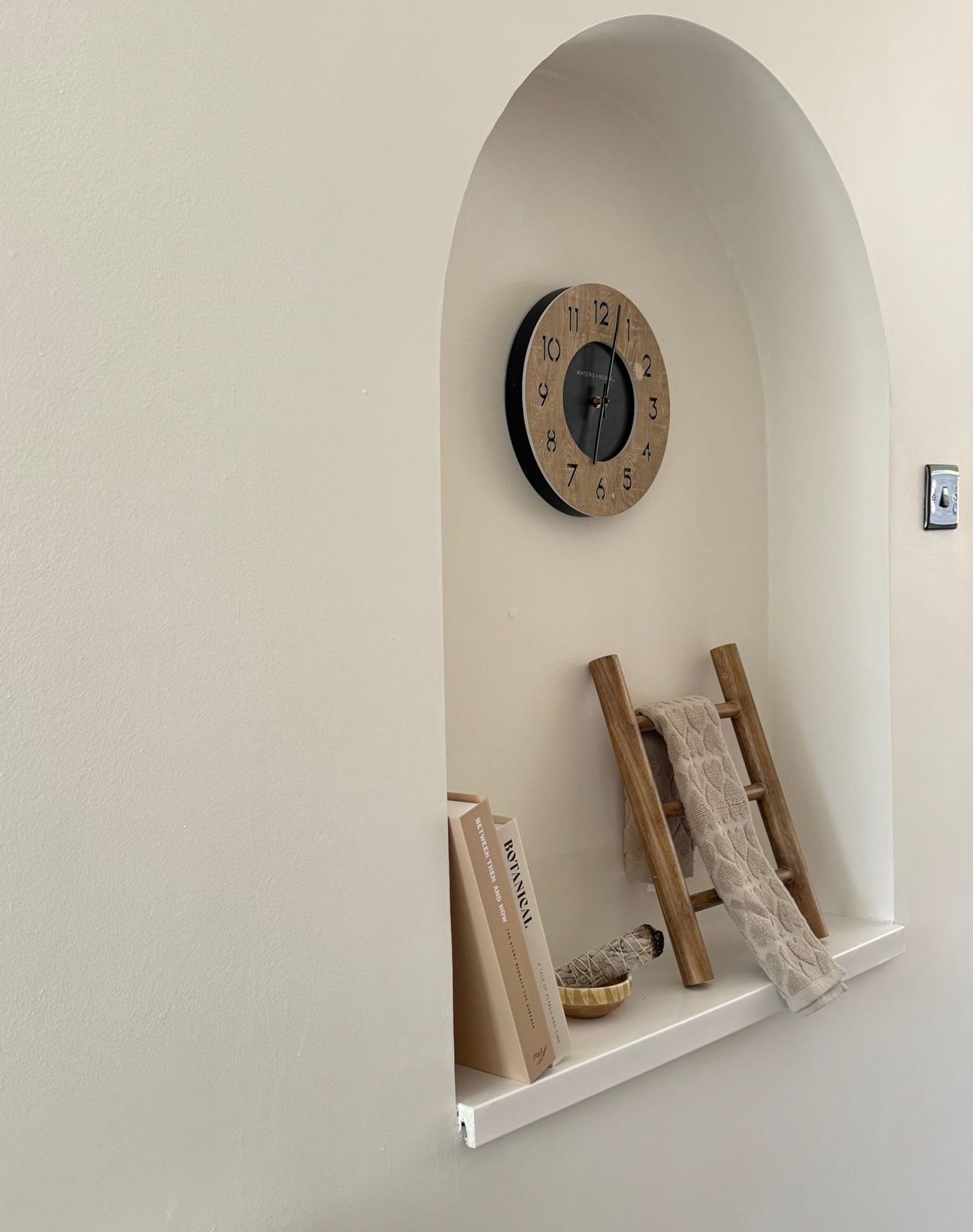 Arched alcove with styled shelf in a renovated home